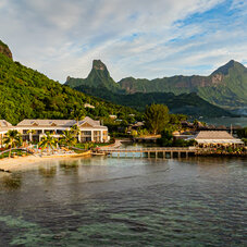 Aerial view of Cook’s Bay Hotel & Suites in Moorea, nestled along the shores of the picturesque Cook’s Bay with crystal-clear waters, lush green mountains, and stunning tropical scenery.