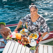 Canoe breakfast delivered by staff at Manava Beach Resort & Spa Moorea, featuring a tropical breakfast experience in the resort’s beautiful lagoon setting.